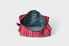 The SB Bag- Rasberry Stripe is a small pouch with pink and red vertical stripes on designer upholstery fabric, lined with blue upcycled cotton featuring a printed animal design. The pouch is open, showcasing the unique interior and label.