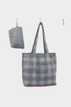 A grey wool plaid tote with a red leather base, from AVAILABLE AT PIERRE LAFOND, hangs on a central hook beside a matching folded accessory, both set against a plain white background.
