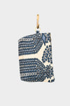 The Indigo Harmony pouch, AVAILABLE AT ABADIR (contact for details), features an indigo block-print with blue and white floral or leaf patterns, hanging from a brass hook by a leather strap against a plain background.