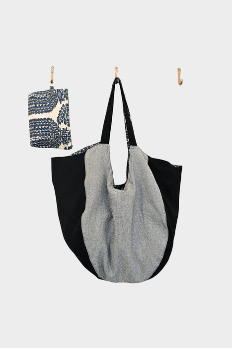 On the middle hook hangs a large, round Bella Bag with black and gray panels. The left hook features the Indigo Harmony accessory (AVAILABLE AT ABADIR, contact for details), and the right hook is empty against a white background.