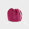 The Poppy Bag Fuchsia Velvet is a round velvet drawstring pouch with white cords, shown against a plain light gray background.