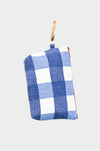 Gingham Coast: A small blue and white checkered gingham pouch with a red zipper and tan leather strap featuring a gold clasp, photographed on a plain light gray background.