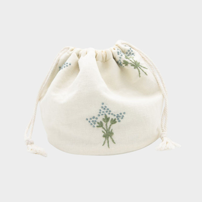 White drawstring pouch with floral embroidery on a white background