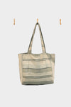 The Sage and Smoke tote bag, crafted from upcycled designer upholstery in beige and gray stripes with a soft sage stripe and green smoke leather base, is AVAILABLE AT ABADIR—contact for details.