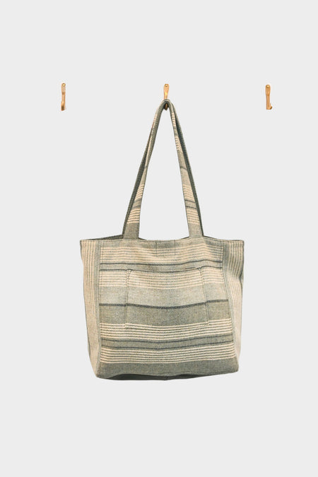 The Sage and Smoke tote bag, crafted from upcycled designer upholstery in beige and gray stripes with a soft sage stripe and green smoke leather base, is AVAILABLE AT ABADIR—contact for details.