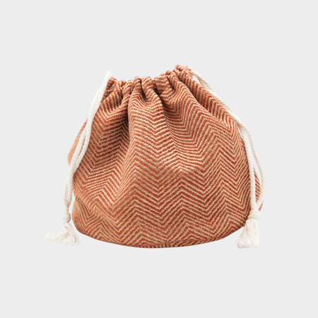 Drawstring bag with herringbone pattern on a light gray background