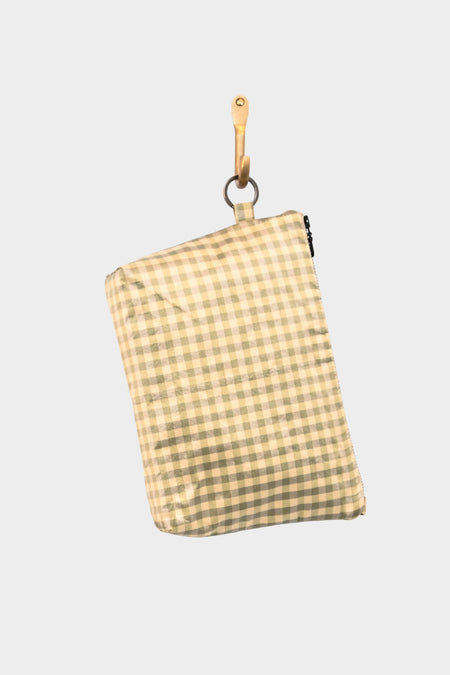 The Meadow Check pouch in beige and light green gingham hangs from a wooden hook against a plain light gray background.
