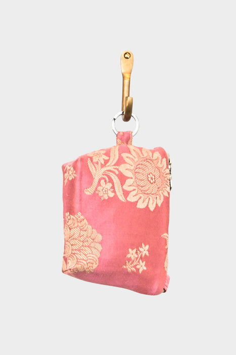 The Mini Mouse Pouch- Blush Rose, featuring pink floral embroidery and a metal ring for easy hanging, is displayed on a wooden hook.