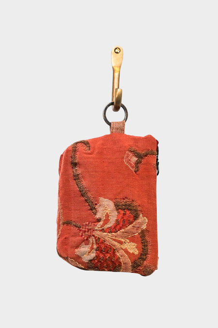 The Mini Mouse Pouch- Autumn Botanics is a small, rectangular pouch with an autumnal floral design, hanging from a brass hook by a metal ring and fabric loop. It features a zipper on one side.
